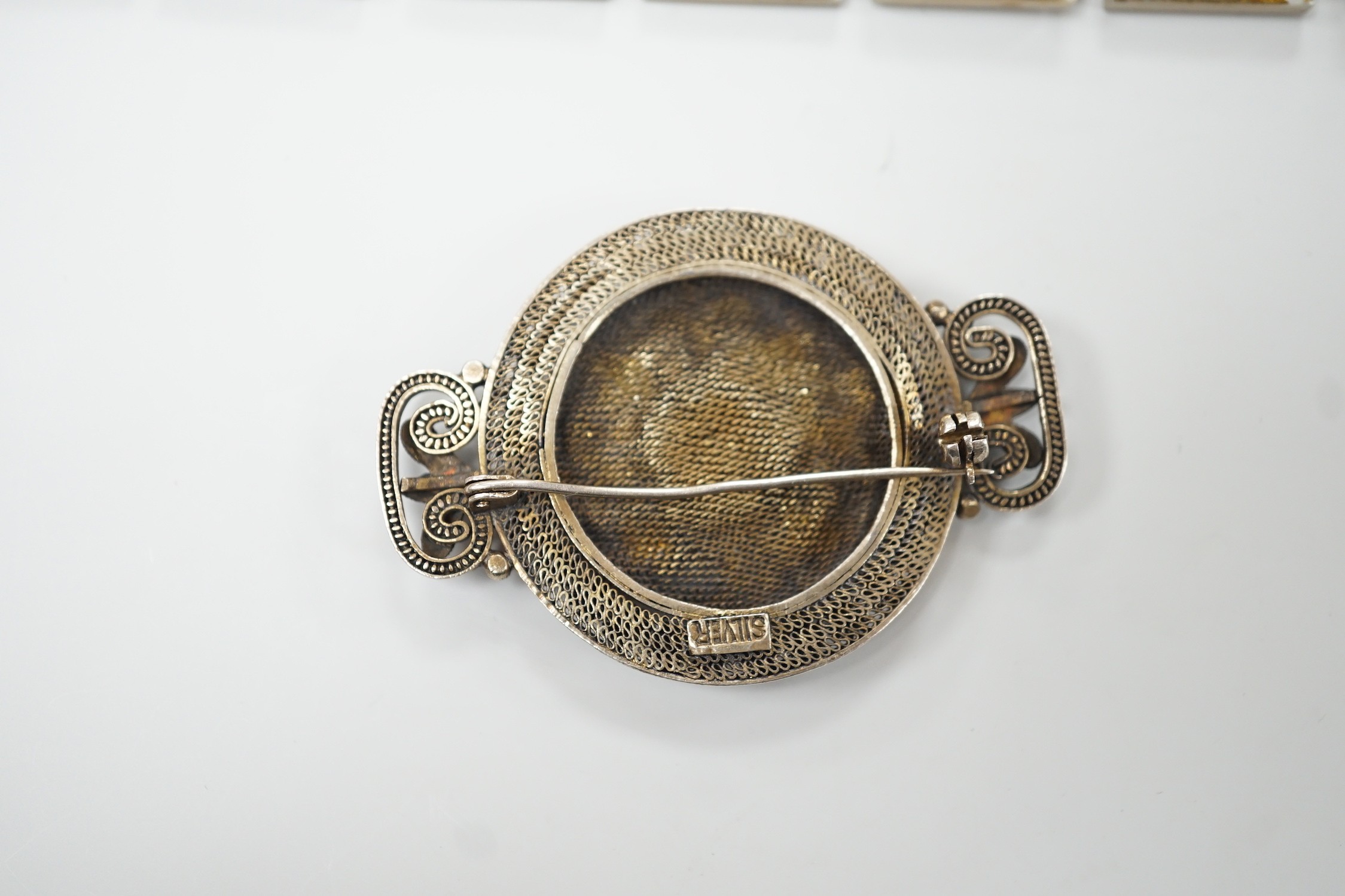 A Persian lacquered mother of pearl panel bracelet, 17cm and a Chinese filigree white metal and 'kingfisher' enamelled brooch, 54mm.